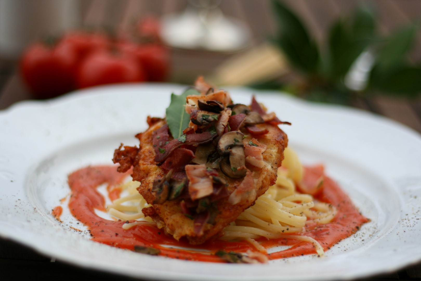 Piccata milanese - kleine Kalbsschnitzerl im Ei-Parmesan-Mantel, getoppt mit einer Röstmischung aus Pilzen, Zunge und Schinken, dazu Spaghetti und Nonnas Tomatensauce